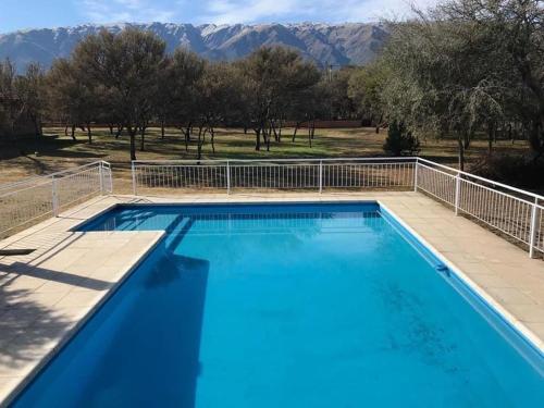 a large blue swimming pool with mountains in the background at Amor y Paz in Carpintería
