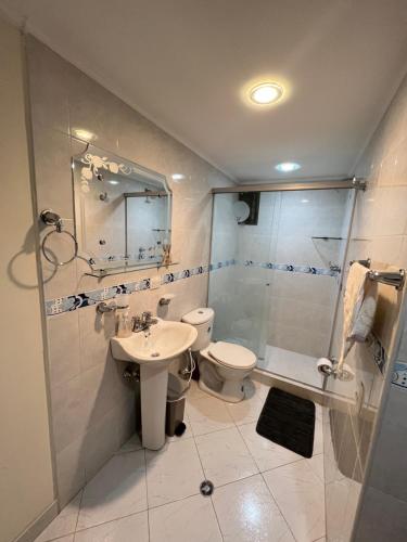 uma casa de banho com um WC, um chuveiro e um lavatório. em Lovely apartment in the best zone of Medellin em Medellín