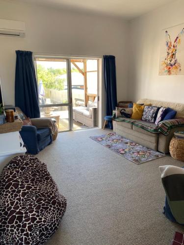 a living room with a couch and a chair at Wee Blue BnB- Central Cosy Villa in Timaru