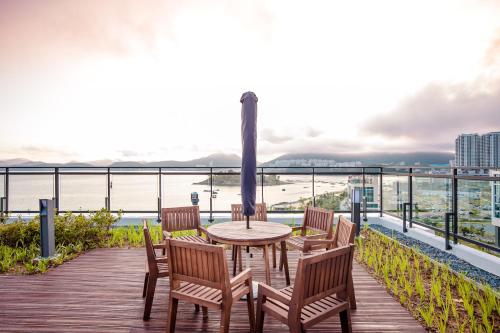 a table and chairs on a deck with a view of the ocean at Lotte Castle Marina in Yeosu