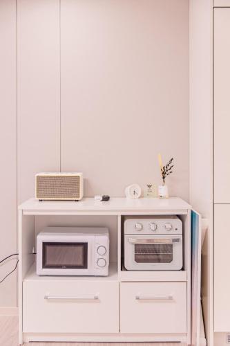 a white kitchen with a microwave and a stove at Lotte Castle Marina in Yeosu