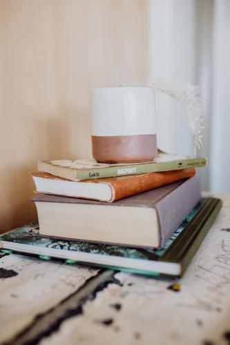 una pila de libros sentados en un estante en Cool and Calm on Kiama, en St Helens