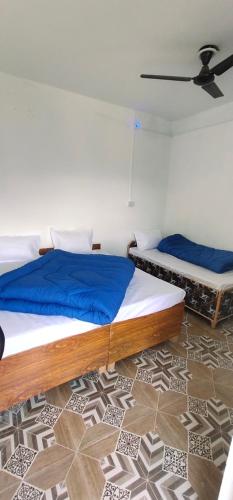 - une chambre avec 2 lits avec des draps bleus dans l'établissement Hotel Holy Spirit, à Phata