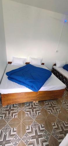- une chambre dotée d'un grand lit avec des draps bleus dans l'établissement Hotel Holy Spirit, à Phata