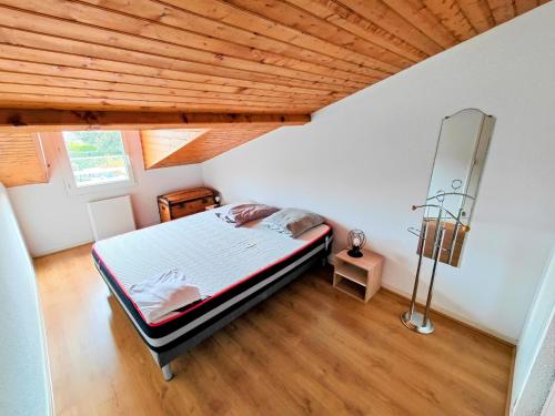 ein Schlafzimmer mit einem Bett und einer Holzdecke in der Unterkunft Villa "les jardins de saint palais sur mer" in Saint-Palais-sur-Mer