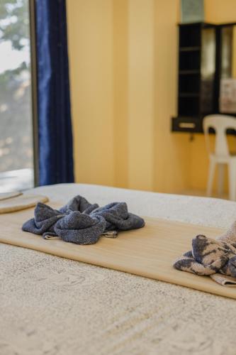 a wooden cutting board with towels on a bed at Amami Beachfront Villa with Private Beach in Puerto Galera