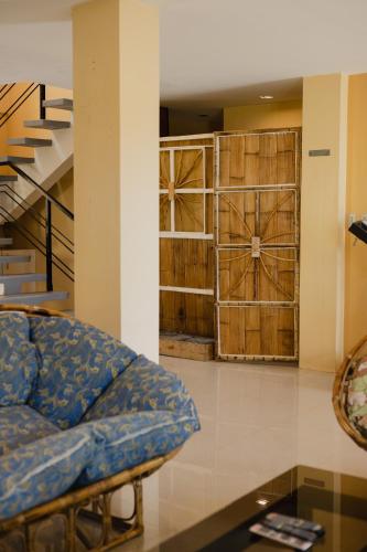 a living room with a couch and wooden doors at Amami Beachfront Villa with Private Beach in Puerto Galera