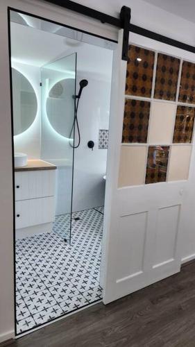 a bathroom with a shower and a glass door at Heritage cottage in South Hobart in Hobart