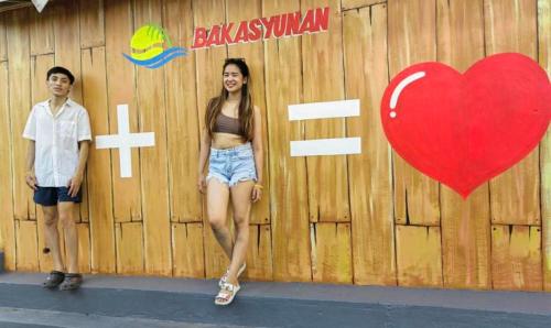 a man and a woman standing next to a wooden fence at Bakasyunan Resort and Conference Center - Zambales in Iba