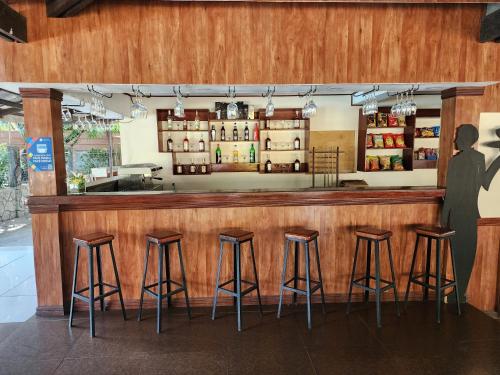 a bar with four stools in a restaurant at Bakasyunan Resort and Conference Center - Zambales in Iba