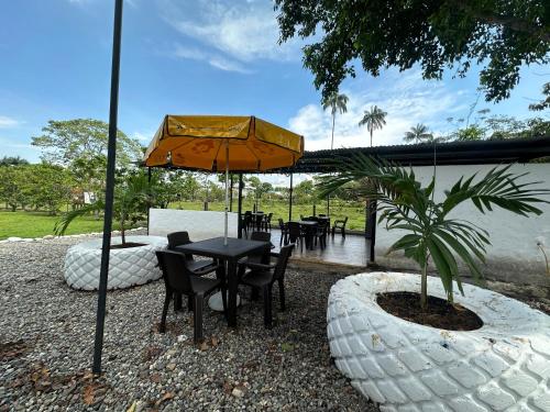 a patio with a table and chairs and an umbrella at Cabañas Campestres en Villavicencio in Villavicencio