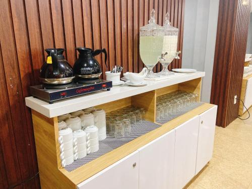 a shelf with bottles and pitchers on it at Valencia Da Nang Beach Hotel in Danang