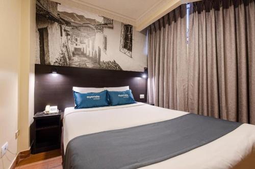 a bedroom with a large bed with blue pillows at Hotel María Luisa in Lima