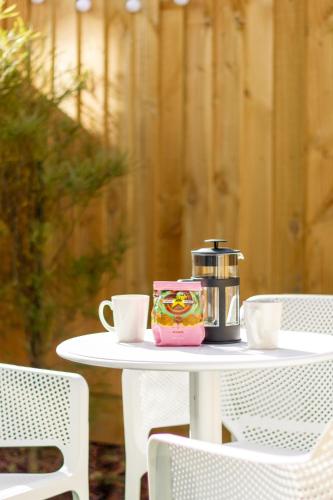 a table with a coffee maker and cups on it at Central City Awaits 2 bed 2 bath in Christchurch