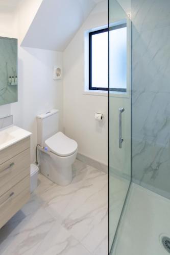 a bathroom with a toilet and a glass shower at Central City Awaits 2 bed 2 bath in Christchurch