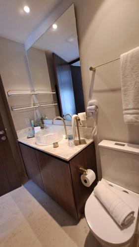 a bathroom with a sink and a toilet and a mirror at Luxury 2 bedrooms Bolongo Punta Mita in Higuera Blanca