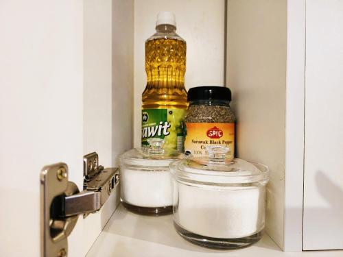 two jars of spices and a bottle of oil in a refrigerator at Kozi Square Twin Room with free Wi-fi & Carpark in Kuching