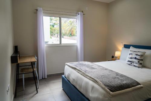 菲利普斯堡的住宿－Modern 3BR Home with Own Private Pool，一间卧室配有一张床、一个窗口和一张书桌