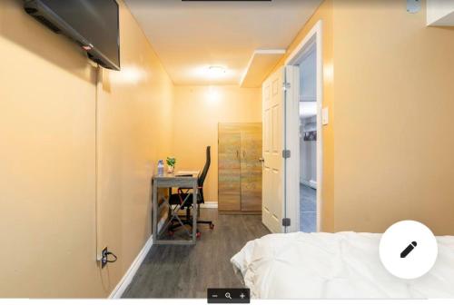a bedroom with a bed and a desk with a computer at Serenity & memorable Cozy Lower Level Apartment Room in TownHouse Private Entrance in Gatineau