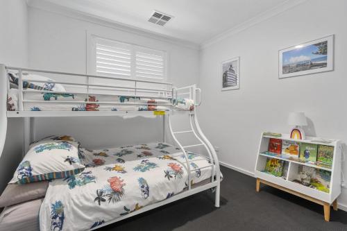 a white bedroom with a bunk bed and a shelf at Break Away 46 Hindmarsh RD McCracken in McCracken