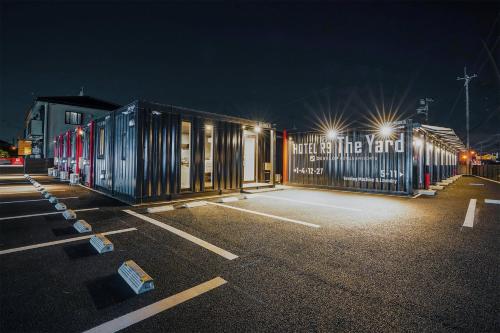 ein Parkplatz in der Nacht mit einem Gebäude mit Beleuchtung in der Unterkunft HOTEL R9 The Yard Yuki in Yuki