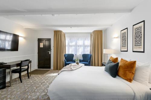a hotel room with a large bed and a desk at Scenic Hotel Cotswold in Christchurch