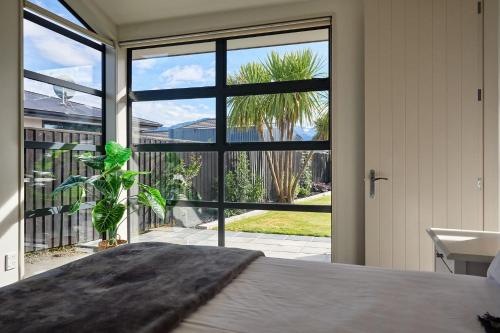 a bedroom with a bed and a large window at Whanau Retreat in Kaikoura