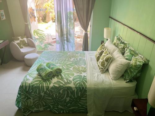 1 dormitorio con 1 cama con edredón verde y blanco en DICI Co-Living Housing Cabo San Lucas en Cabo San Lucas