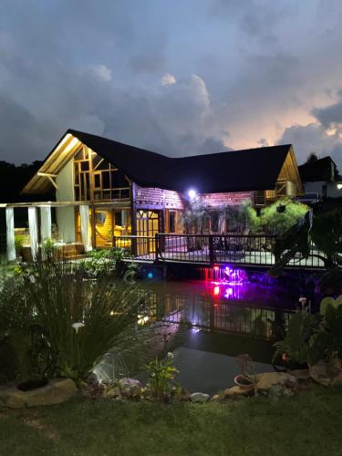 une maison avec un étang devant elle la nuit dans l'établissement Chalet del lago Santa Elena, à Santa Elena
