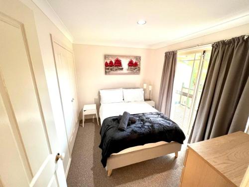 a small bedroom with a bed and a window at 3 Bedroom Town house near Gosford CBD Sleeps 6 plus in Gosford