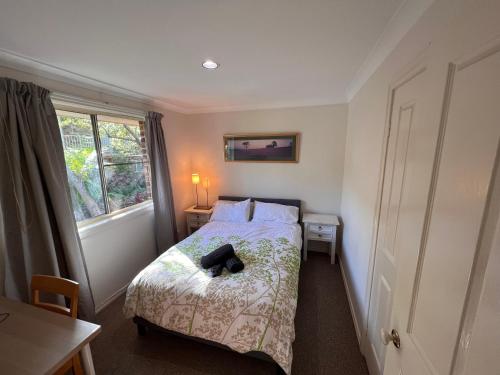 un pequeño dormitorio con una cama con sombrero en 3 Bedroom Town house near Gosford CBD Sleeps 6 plus en Gosford