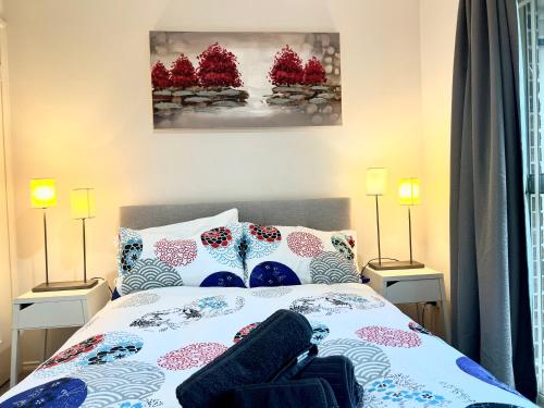 a bedroom with a bed with two lamps on both sides at 3 Bedroom Town house near Gosford CBD Sleeps 6 plus in Gosford