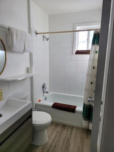 La salle de bains est pourvue d'une baignoire, de toilettes et d'un lavabo. dans l'établissement Midtown Motel on Alaska Ave, à Dawson Creek