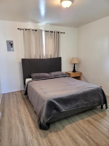 a bedroom with a large bed and a wooden floor at Midtown Motel on Alaska Ave in Dawson Creek