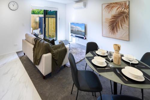 a living room with a table and a couch at The City's Best Kept Secret 2 bed 2 bath in Christchurch