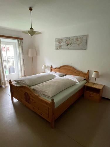 a bedroom with a large wooden bed in a room at Zimmer 1 am Manötscherhof in Tires