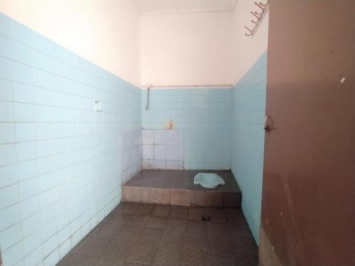 a small bathroom with a toilet in the corner at Hotel O Tetirah Homestay in Salatiga