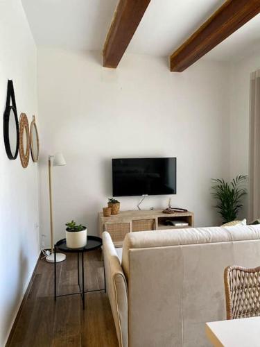 a living room with a couch and a flat screen tv at Nikolina Flat in Xlendi