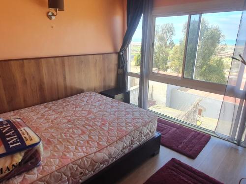 - une chambre avec un lit et une grande fenêtre dans l'établissement DAR MAALAM LAHCEN x طريق الوليدية, à El Jadida