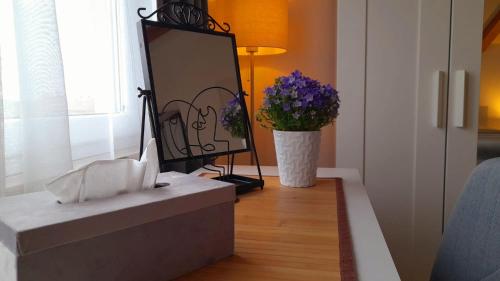 a mirror and a vase of flowers in a room at Apartman Diana,free parking in Pula