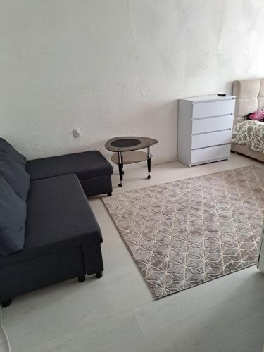 ein Wohnzimmer mit einem Sofa und einem Tisch in der Unterkunft Viršu street apartaments 5 in Liepāja