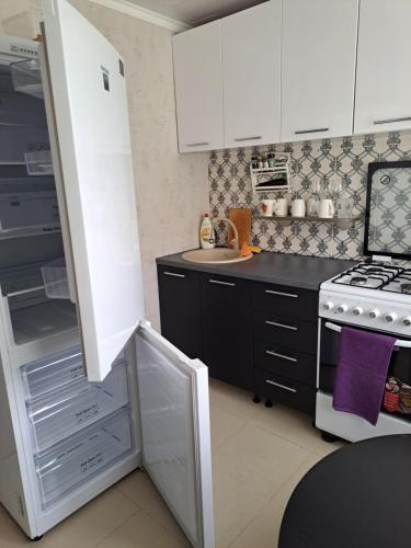 kuchnia z kuchenką i otwartą lodówką w obiekcie Viršu street apartaments 5 w mieście Lipawa