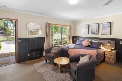 a bedroom with a bed and a couch and chairs at All Seasons Mansfield in Mansfield