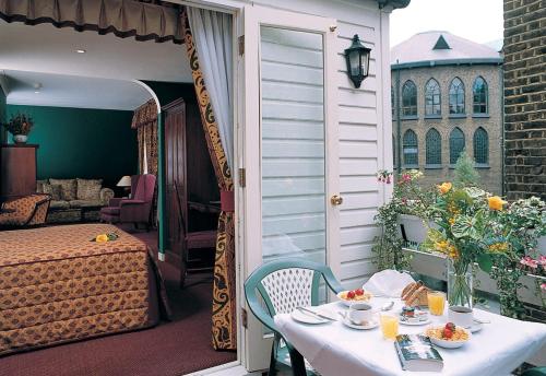 a patio with a table and a bed and a room at Berjaya Eden Park London Hotel in London