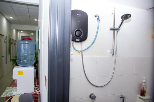 um chuveiro com uma mangueira ligada a uma parede em Just Stay Inn Guest House em Malaca