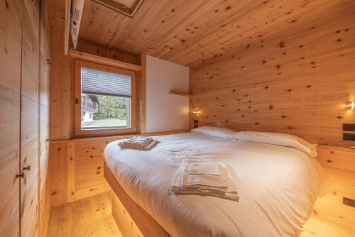 a bedroom with a bed in a wooden cabin at Casa Ca dei Pini in Cortina dʼAmpezzo