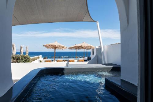 una piscina con vistas al océano desde una casa en Almyra Oia Suites, en Oia