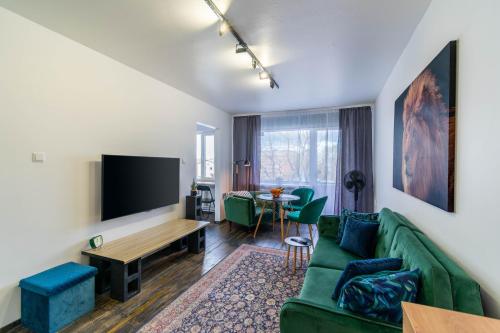 een woonkamer met een groene bank en een flatscreen-tv bij Apartments24 Laada 4 in Rakvere