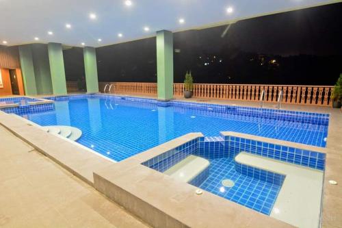 a large swimming pool with blue tiles in a building at Carol Crosswinds Tagaytay in Cavite