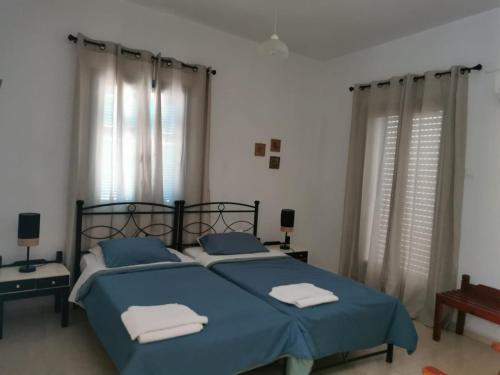 a bedroom with a bed with blue sheets and towels at Nikos Hotel in Diafani